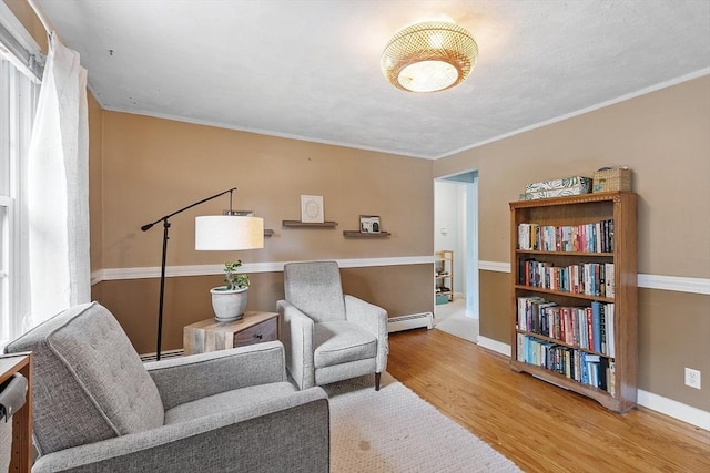 7 Squannacook Ter, Townsend, MA 01469 - living area featuring wood finished floors, a baseboard radiator, baseboard heating, baseboards, and crown molding