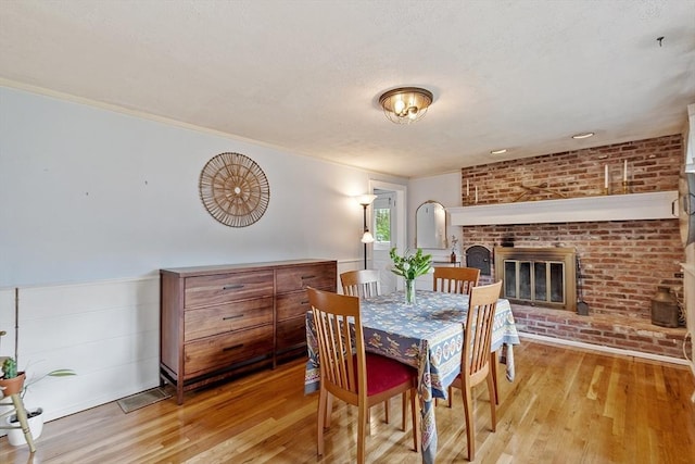 7 Squannacook Ter, Townsend, MA 01469 - dining area with hardwood / wood-style floors, a brick fireplace, and a textured ceiling