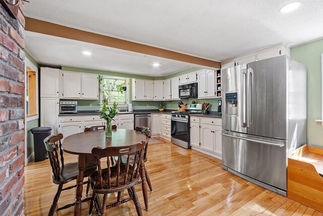 7 Squannacook Ter, Townsend, MA 01469 - kitchen featuring appliances with stainless steel finishes, dark countertops, light wood finished floors, white cabinetry, and recessed lighting