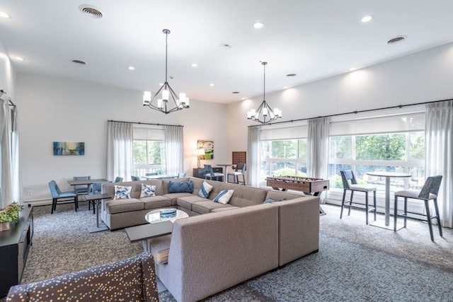 carpeted living room with pool table and a chandelier