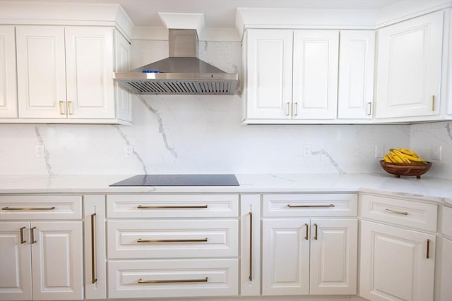 kitchen with wall chimney exhaust hood, backsplash, black electric cooktop, and white cabinets