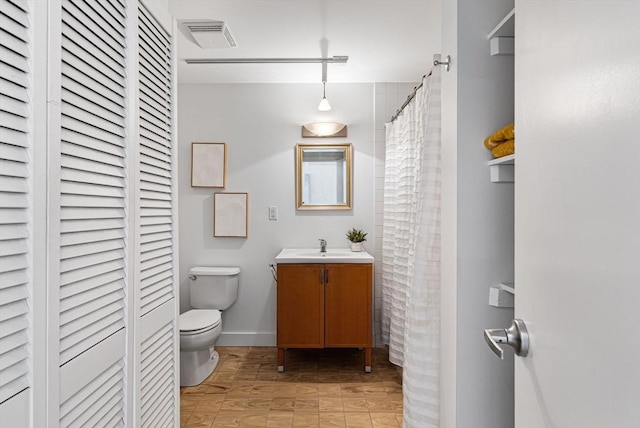 bathroom featuring a closet, visible vents, toilet, and vanity