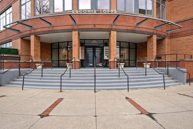 property entrance featuring french doors and brick siding