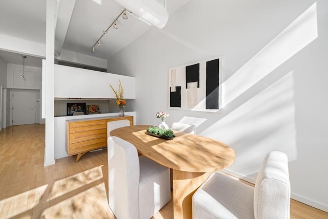 dining area with track lighting and light wood finished floors