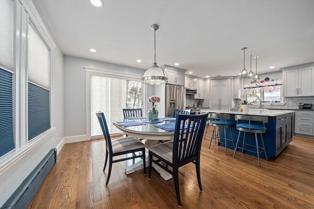 dining area featuring a baseboard heating unit and dark wood-type flooring