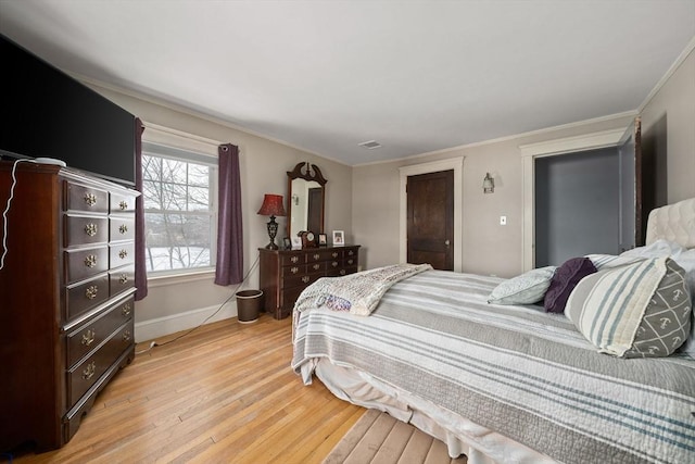 bedroom with crown molding and light hardwood / wood-style floors