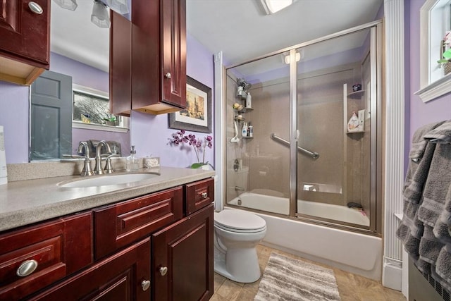 full bathroom with vanity, enclosed tub / shower combo, and toilet