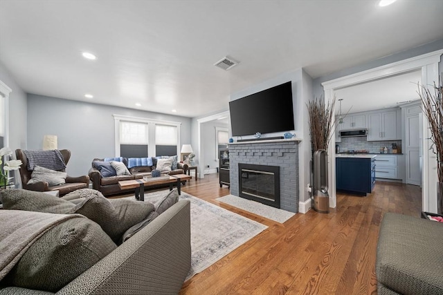 living room with hardwood / wood-style flooring and a fireplace