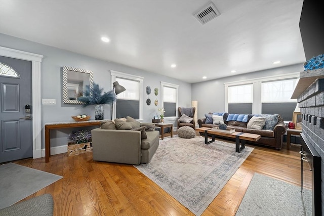 living room featuring hardwood / wood-style flooring and a brick fireplace