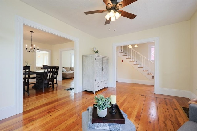 6 Minerva St, Swampscott, MA 01907 - living area with stairs, light wood-style floors, ceiling fan, a chandelier, and baseboards