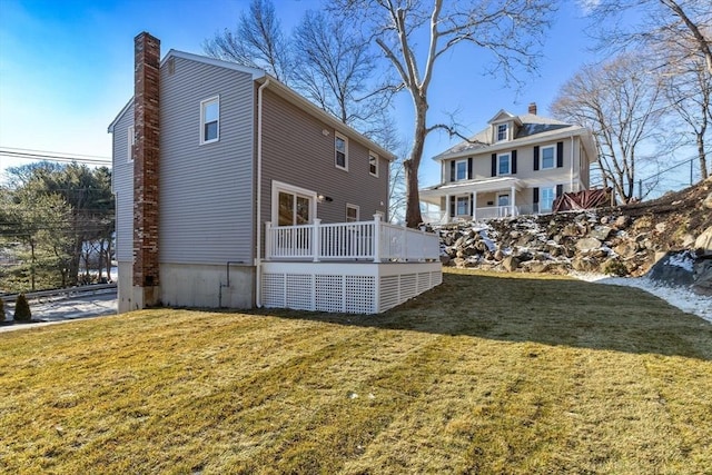 view of side of home featuring a deck and a yard