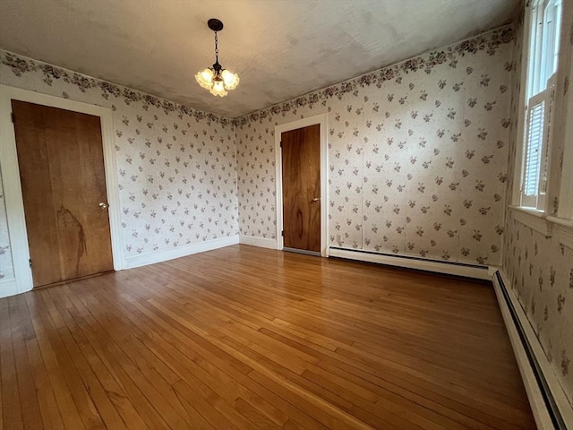 909 High St, Fall River, MA 02720 - unfurnished room featuring baseboard heating, wallpapered walls, a chandelier, hardwood / wood-style flooring, and baseboards