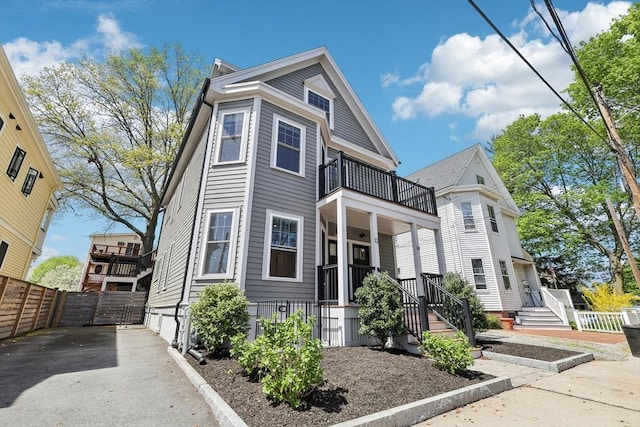 view of front of property with a balcony, fence, and covered porch