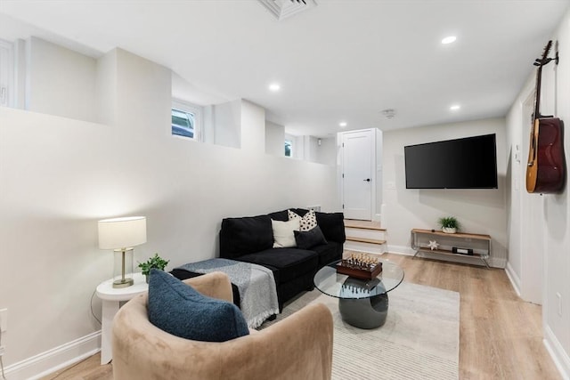 living room with light wood-type flooring, baseboards, and recessed lighting