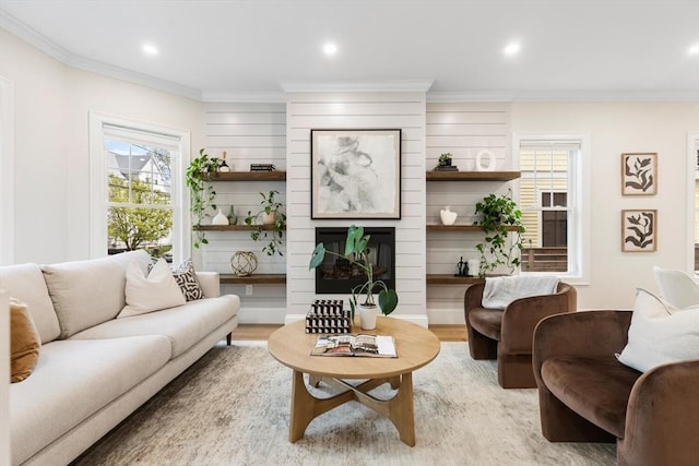 living room featuring light wood-type flooring, ornamental molding, recessed lighting, and a fireplace