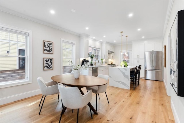 dining room with light wood-type flooring, crown molding, recessed lighting, and baseboards