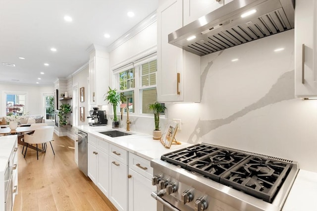 kitchen featuring custom range hood, appliances with stainless steel finishes, crown molding, recessed lighting, and white cabinets