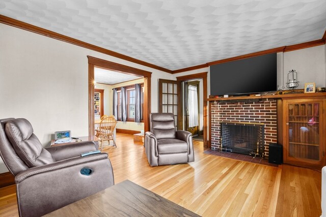 living room with ornamental molding, a fireplace, and hardwood / wood-style flooring