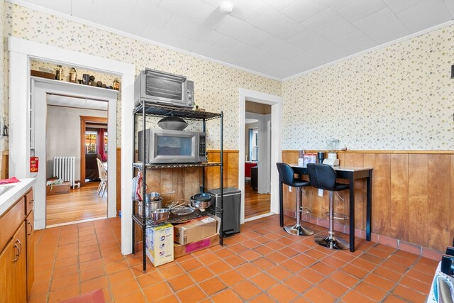 kitchen featuring ornamental molding, hardwood / wood-style flooring, and radiator