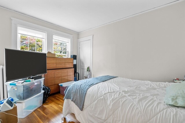 bedroom with crown molding and wood-type flooring