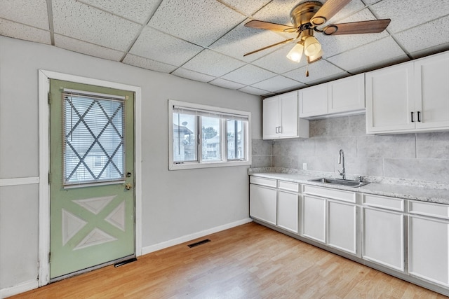 kitchen featuring sink, light wood-type flooring, and a paneled ceiling