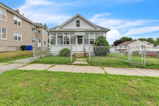 bungalow-style house featuring a sunroom and a front lawn