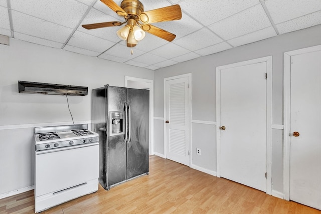 kitchen featuring black fridge with ice dispenser, gas range gas stove, ceiling fan, and light hardwood / wood-style floors