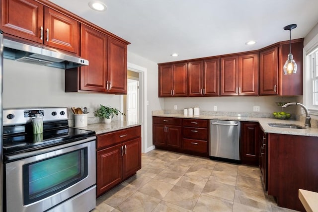 kitchen featuring light stone counters, sink, decorative light fixtures, and appliances with stainless steel finishes