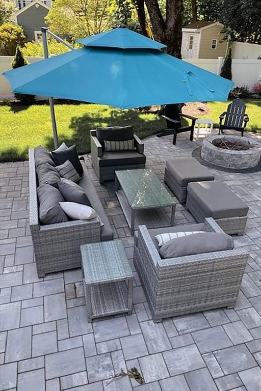 view of patio with an outdoor living space with a fire pit