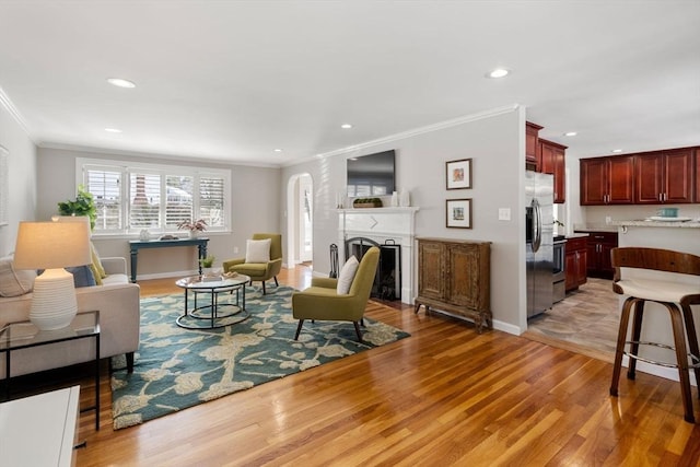 living room with crown molding and light wood-type flooring