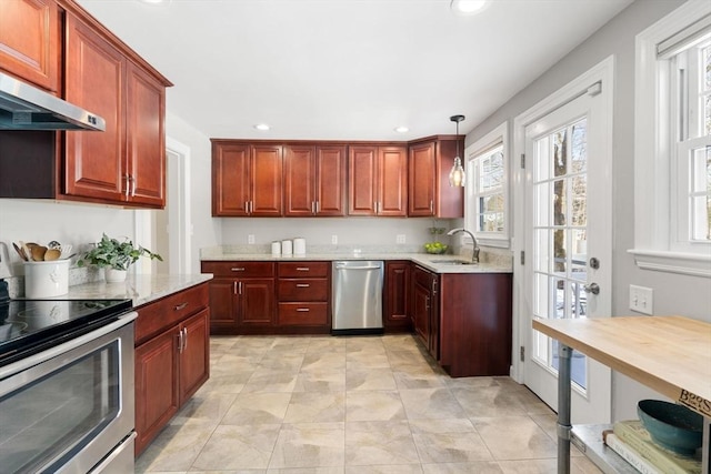 kitchen with pendant lighting, sink, light stone counters, and appliances with stainless steel finishes