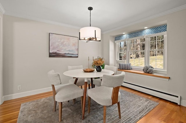 dining room with crown molding, baseboards, light wood-type flooring, and a baseboard radiator