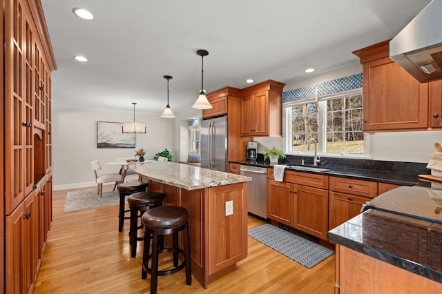 kitchen with a kitchen island, recessed lighting, stainless steel appliances, light wood-style floors, and wall chimney exhaust hood