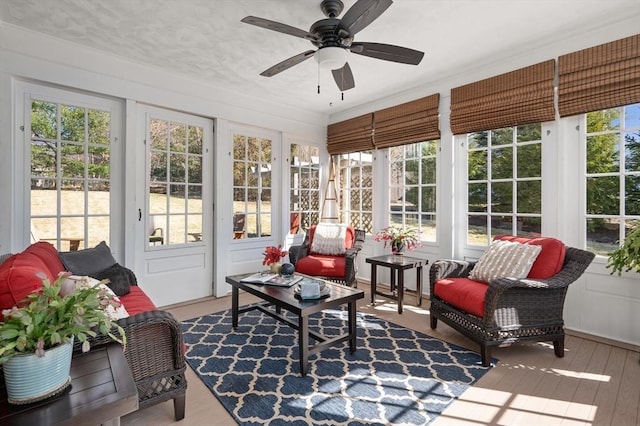 sunroom / solarium featuring plenty of natural light and a ceiling fan