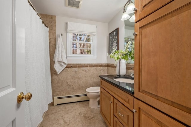 bathroom featuring visible vents, toilet, tile walls, a baseboard radiator, and vanity