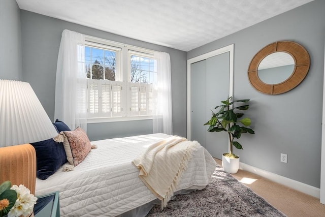 bedroom with a closet, baseboards, and carpet floors