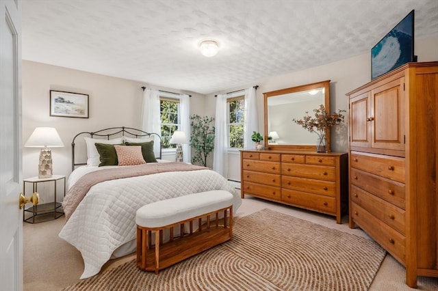 bedroom with light carpet and a textured ceiling