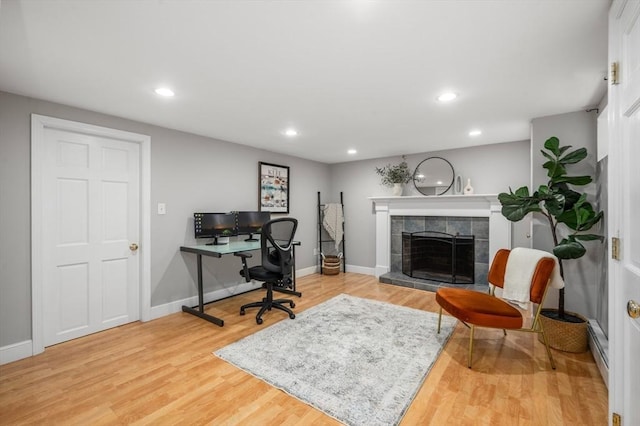 office area with recessed lighting, wood finished floors, baseboards, and a tile fireplace