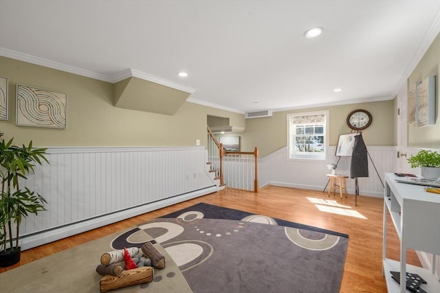 living area featuring visible vents, wood finished floors, wainscoting, a baseboard radiator, and stairs