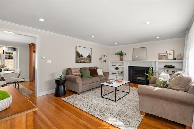 living room with a fireplace, wood finished floors, baseboards, and ornamental molding