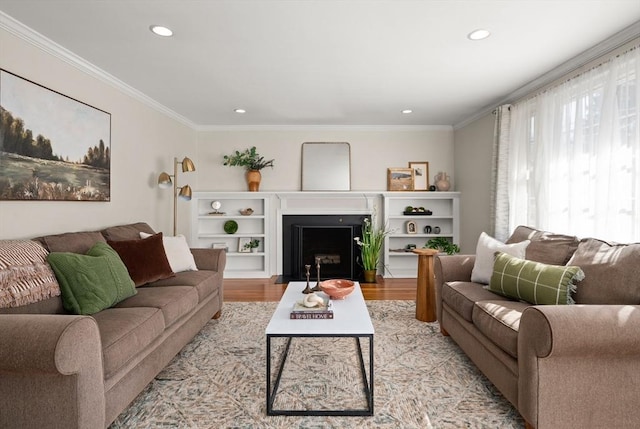 living area featuring light wood finished floors, a fireplace with flush hearth, recessed lighting, and ornamental molding