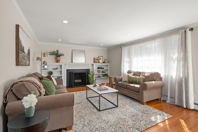 living area with crown molding, a fireplace with flush hearth, wood finished floors, and recessed lighting