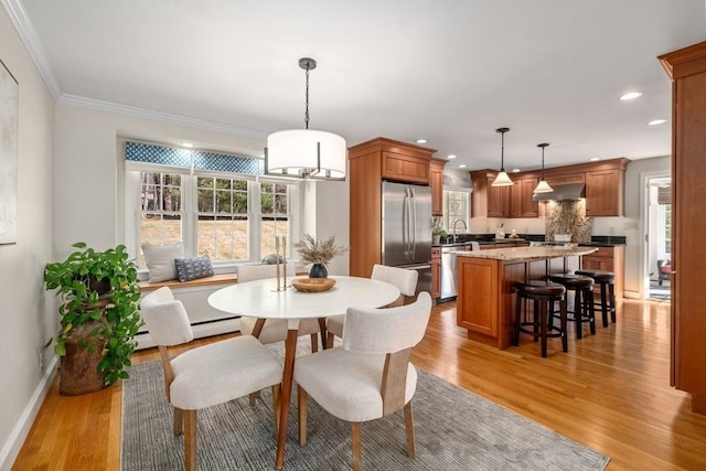 dining space with recessed lighting, baseboards, light wood-style floors, and crown molding