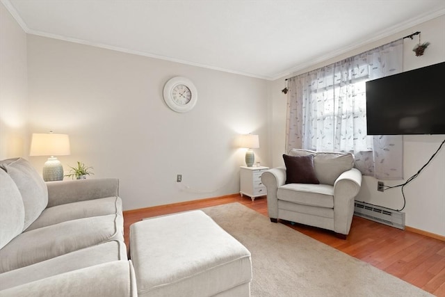 living area featuring ornamental molding, baseboard heating, wood finished floors, and baseboards