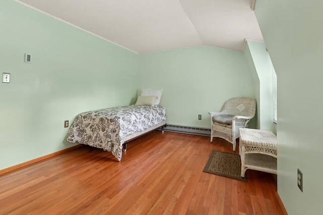 bedroom with lofted ceiling, baseboards, baseboard heating, and wood finished floors