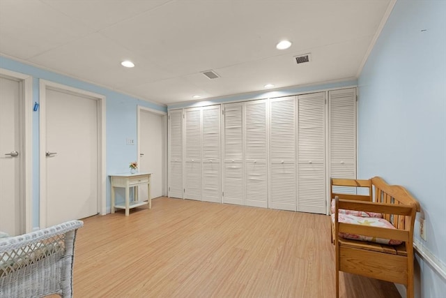 sitting room featuring recessed lighting, visible vents, crown molding, and wood finished floors