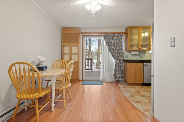 dining area with ceiling fan, light wood finished floors, a baseboard radiator, and crown molding