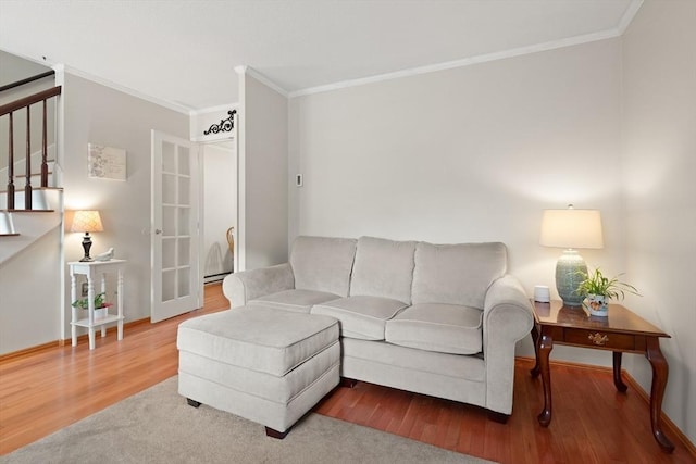 living room with baseboards, crown molding, stairway, and wood finished floors