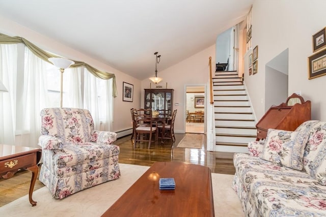 living room featuring light wood-type flooring, vaulted ceiling, stairway, and baseboard heating