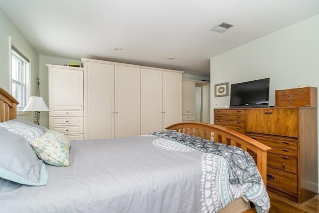 bedroom with visible vents and wood finished floors